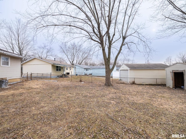 view of yard featuring central AC unit and a storage shed