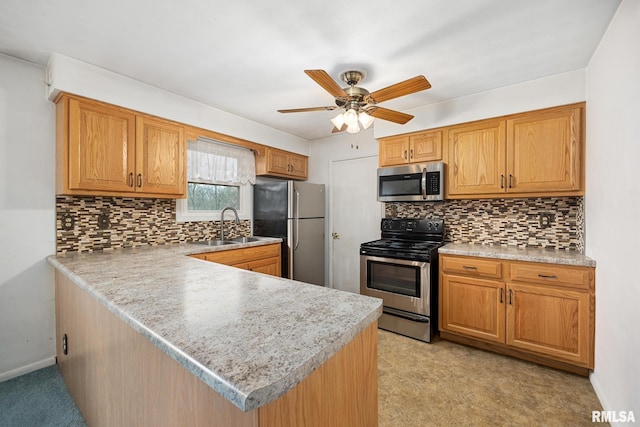 kitchen with sink, backsplash, ceiling fan, kitchen peninsula, and stainless steel appliances