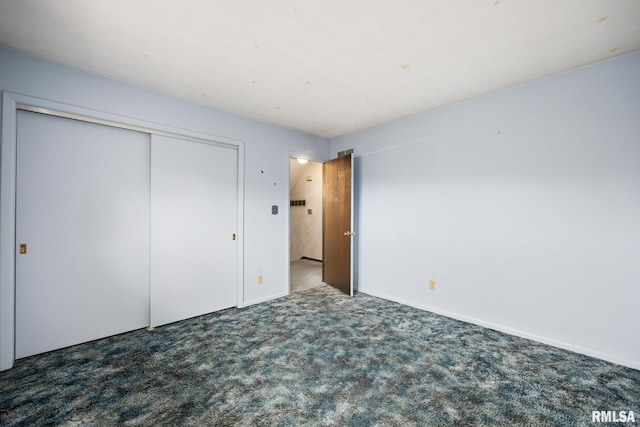 unfurnished bedroom with a closet and dark colored carpet