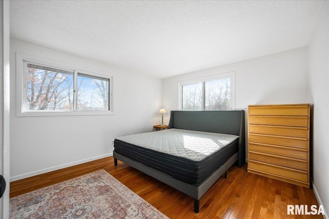 bedroom with hardwood / wood-style flooring and a textured ceiling