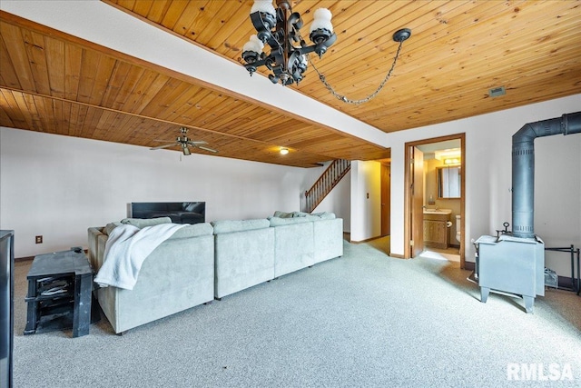 living room featuring ceiling fan, wooden ceiling, and a wood stove