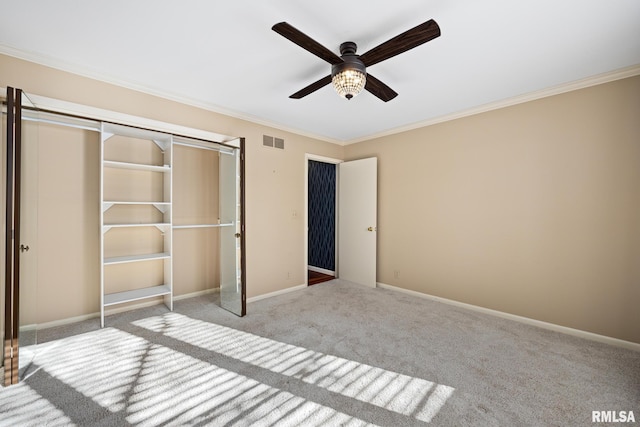 unfurnished bedroom featuring crown molding, light colored carpet, a closet, and ceiling fan