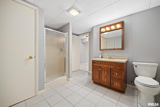 bathroom with vanity, tile patterned flooring, a shower with shower door, and a drop ceiling