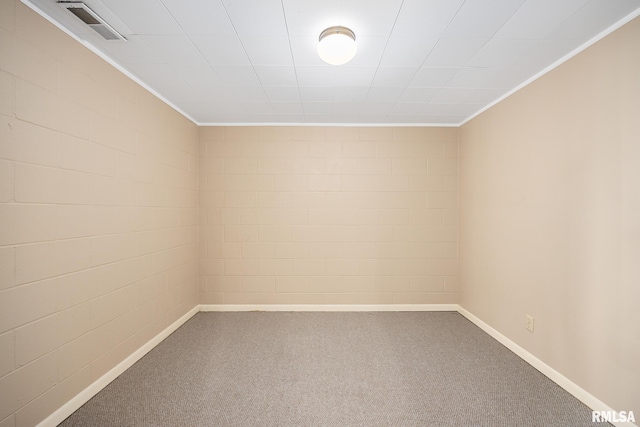 carpeted spare room with ornamental molding and brick wall