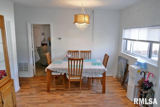 dining area with a chandelier and light hardwood / wood-style floors