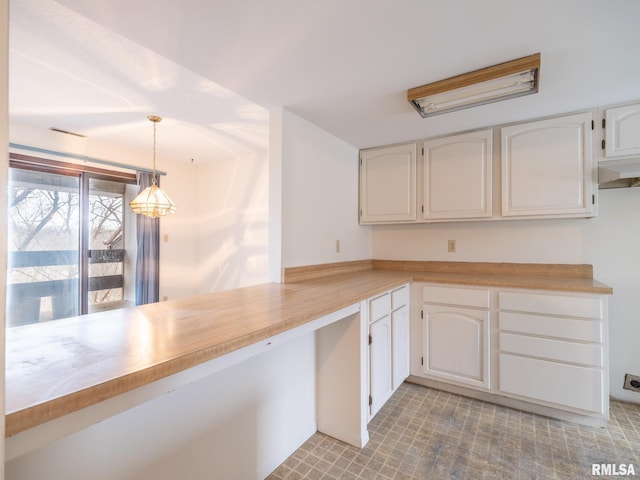 kitchen with hanging light fixtures and white cabinets