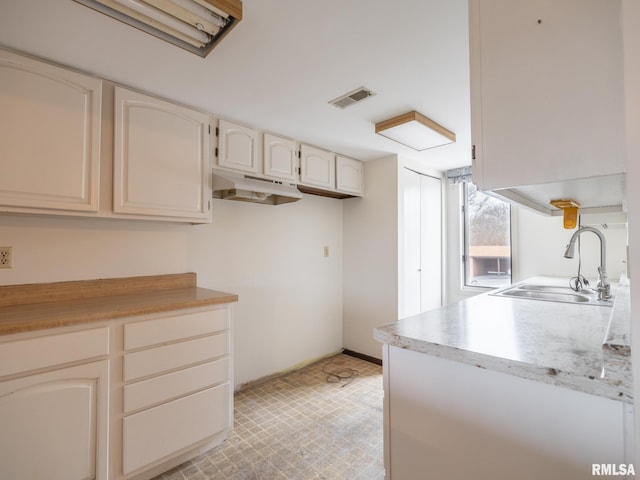 kitchen featuring sink and white cabinets