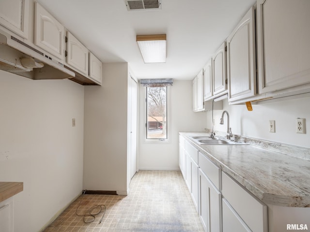 kitchen featuring sink and white cabinets