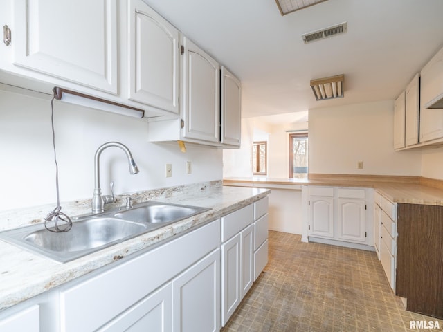 kitchen featuring sink and white cabinets