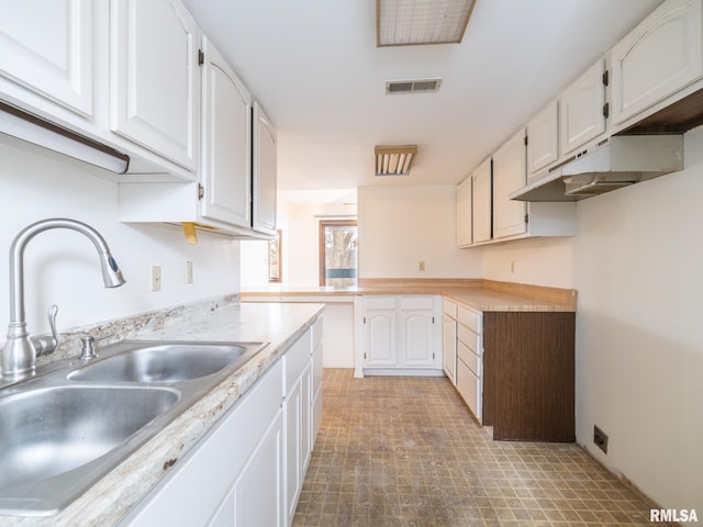 kitchen featuring sink and white cabinets