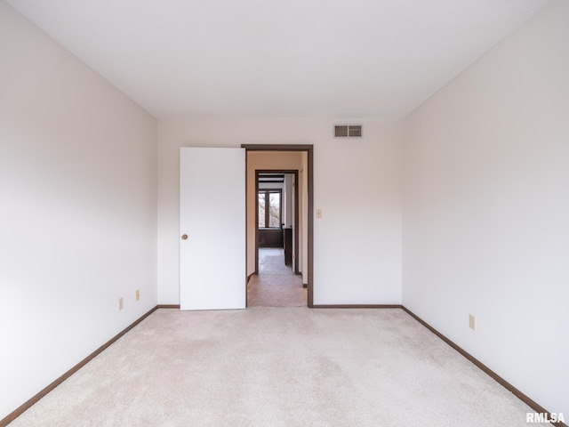 spare room featuring light carpet