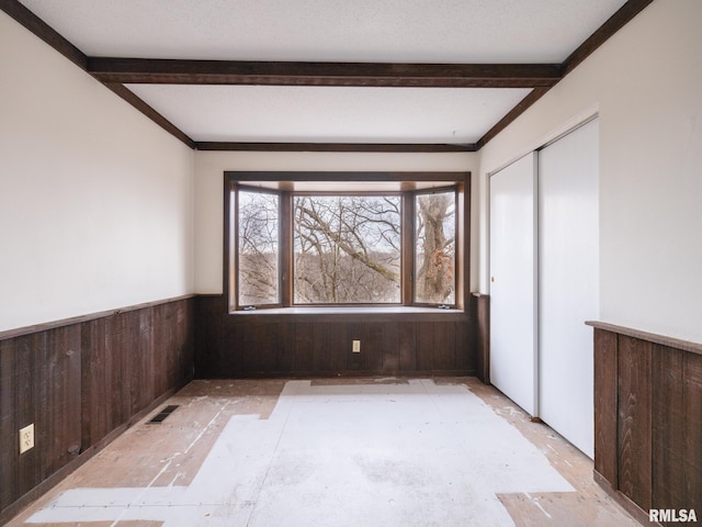 unfurnished room featuring wooden walls