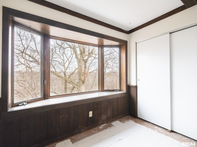 unfurnished bedroom with a closet and wood walls