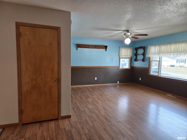 spare room with ceiling fan, hardwood / wood-style floors, and a textured ceiling