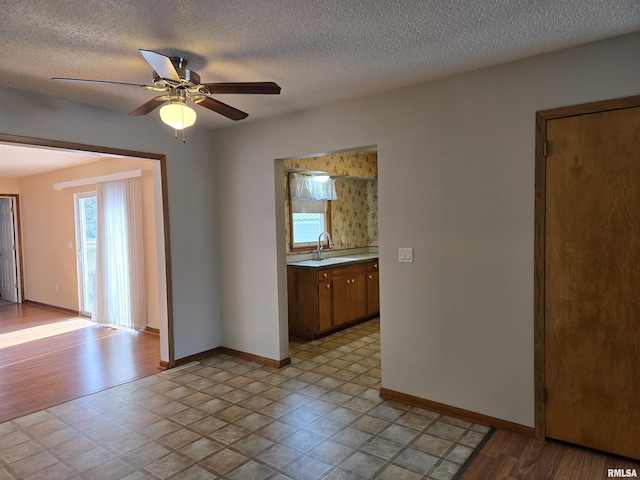 spare room featuring ceiling fan, sink, and a textured ceiling