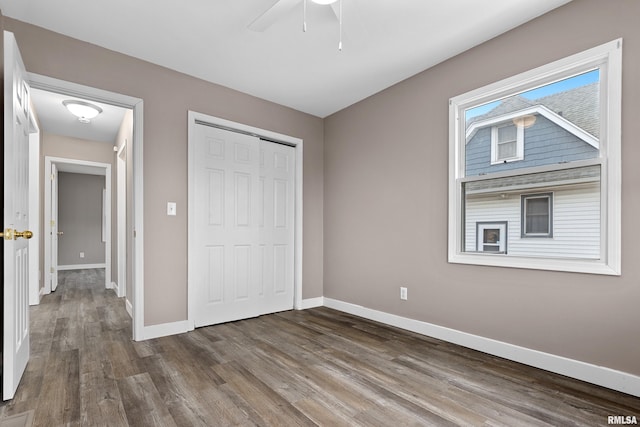 unfurnished bedroom featuring hardwood / wood-style floors, ceiling fan, and a closet