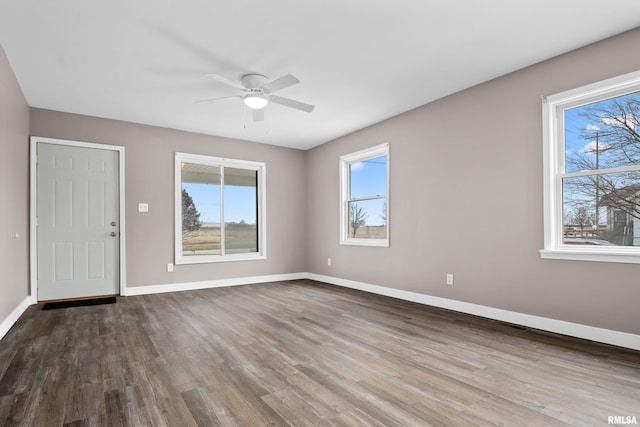 spare room featuring ceiling fan, a healthy amount of sunlight, and wood-type flooring