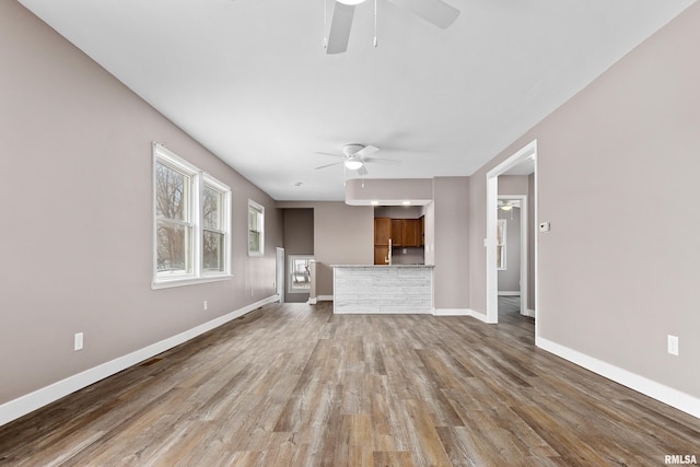 unfurnished living room featuring ceiling fan and wood-type flooring