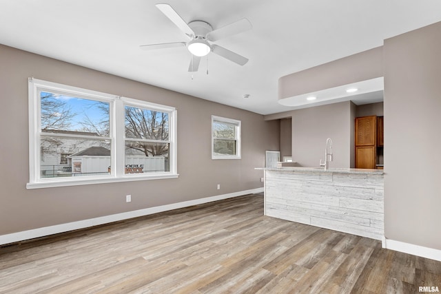 kitchen featuring ceiling fan and light hardwood / wood-style flooring