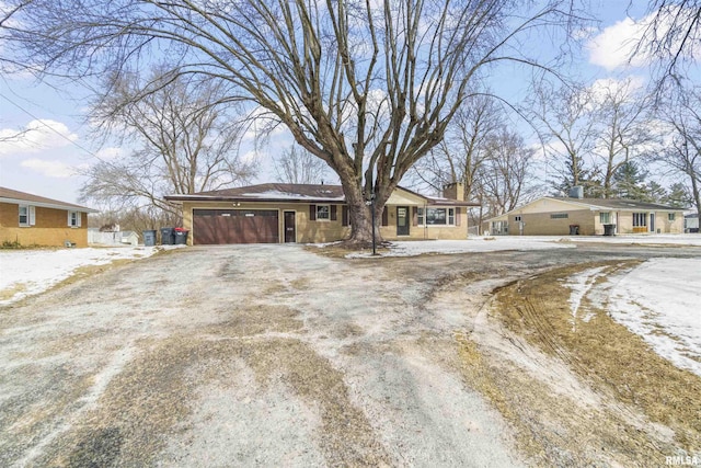 view of front of house featuring an attached garage, driveway, and a chimney