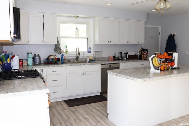 kitchen featuring stainless steel dishwasher, sink, and white cabinetry