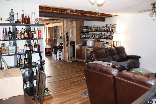 living room featuring wood-type flooring, ceiling fan, and bar area