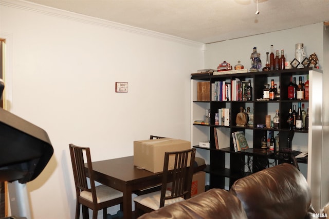 dining space featuring ornamental molding and bar area