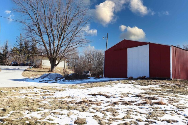 yard layered in snow with an outbuilding