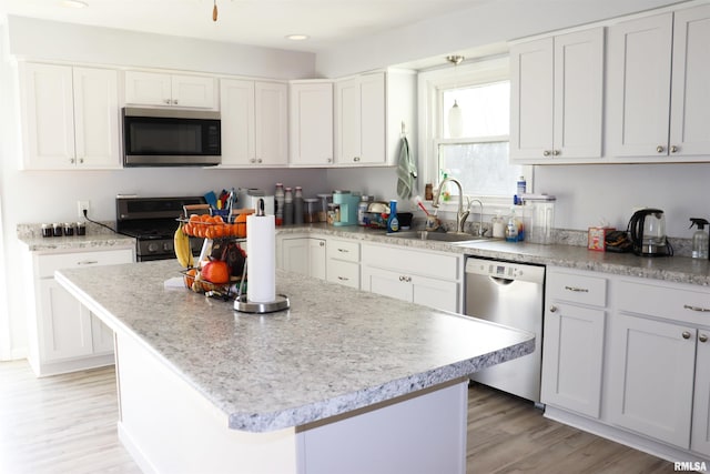 kitchen with white cabinetry, stainless steel appliances, and sink