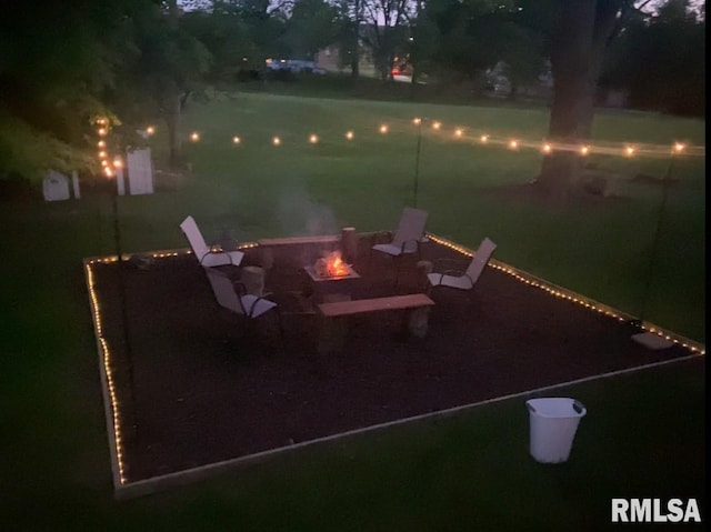 patio at night featuring a fire pit