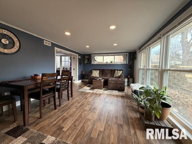 dining space featuring ornamental molding, wood-type flooring, and plenty of natural light