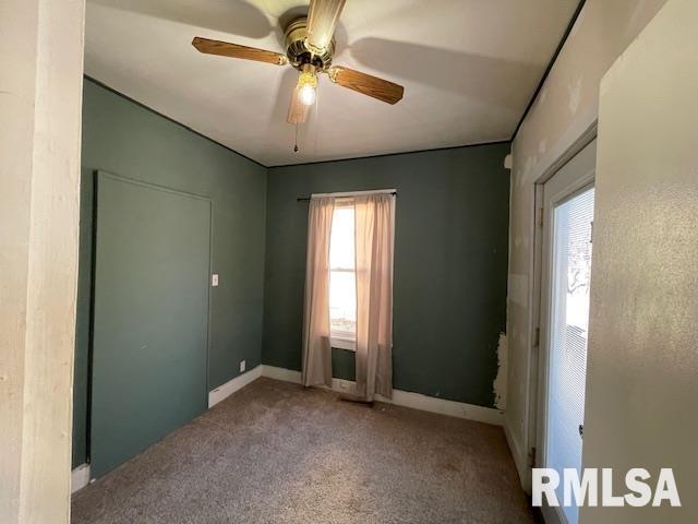 spare room featuring ceiling fan, carpet, and a wealth of natural light