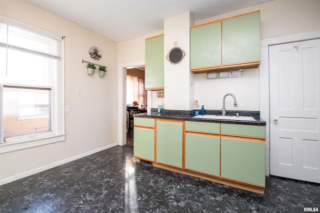 kitchen featuring a healthy amount of sunlight, sink, and green cabinets