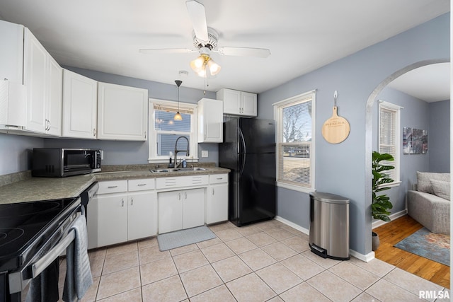 kitchen with white cabinetry, sink, light tile patterned floors, ceiling fan, and black appliances