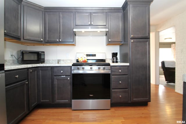 kitchen with stainless steel stove and light hardwood / wood-style flooring