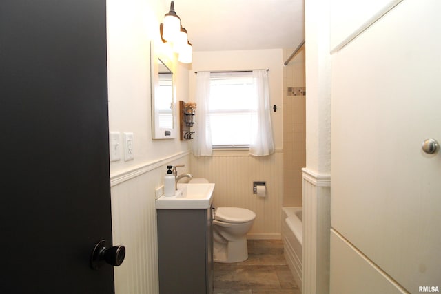 full bathroom featuring vanity, tiled shower / bath, and toilet