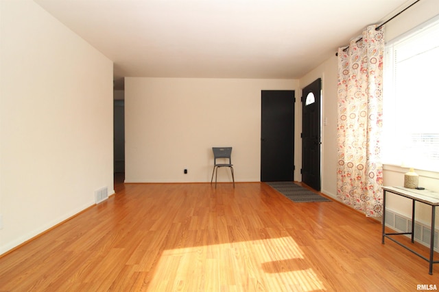 empty room with light hardwood / wood-style flooring