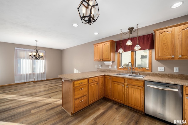 kitchen with decorative light fixtures, dishwasher, sink, and kitchen peninsula