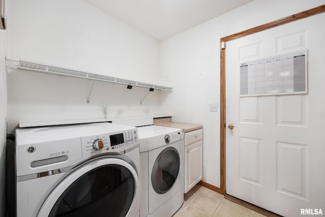 laundry room with cabinets, washing machine and dryer, and light tile patterned flooring