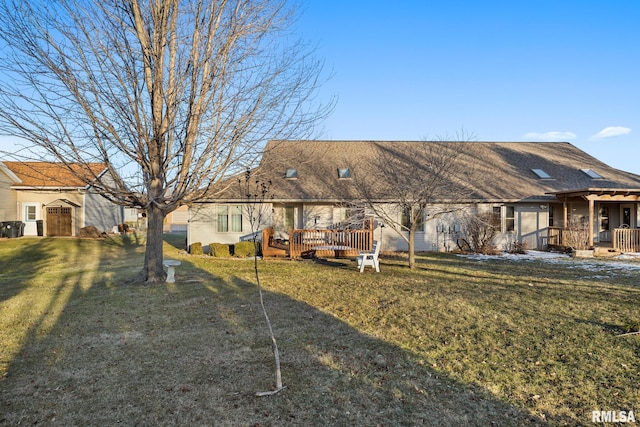 rear view of property with a wooden deck and a lawn