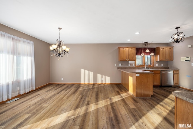 kitchen featuring pendant lighting, sink, stainless steel dishwasher, and kitchen peninsula