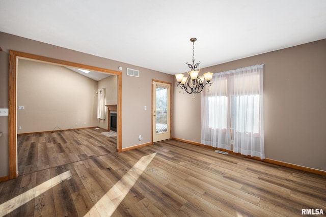 spare room featuring hardwood / wood-style floors and a notable chandelier