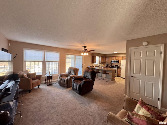 carpeted living room featuring ceiling fan and a textured ceiling