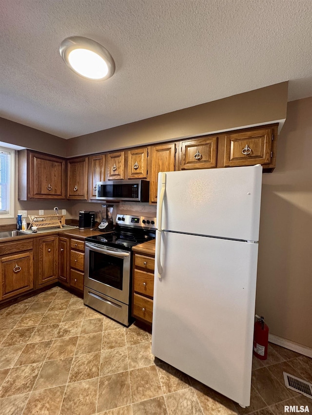 kitchen with stainless steel appliances and a textured ceiling