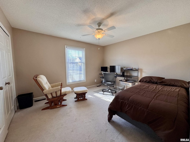 bedroom with ceiling fan, light carpet, and a textured ceiling