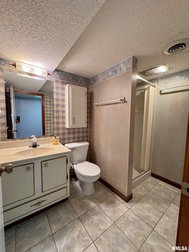 bathroom featuring vanity, a textured ceiling, tile patterned floors, toilet, and walk in shower