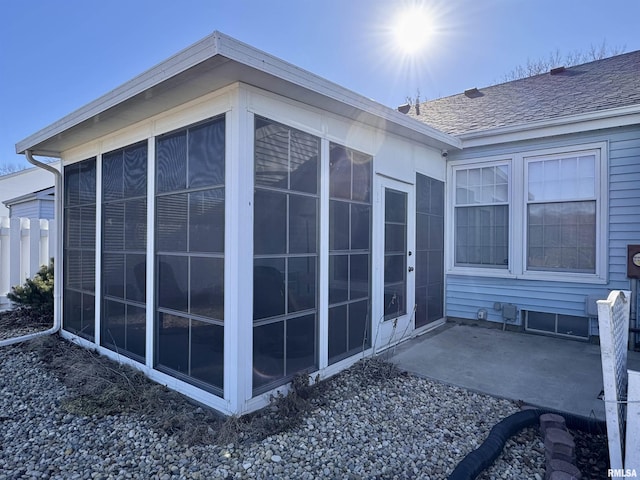 view of property exterior with a patio area and a sunroom