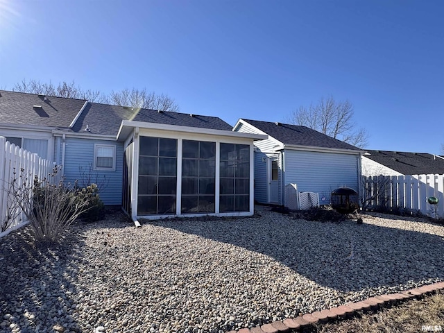 rear view of property featuring a sunroom