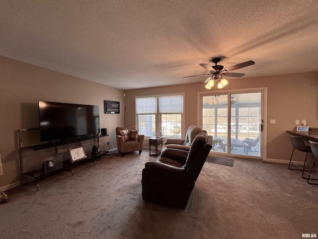 living room with ceiling fan, carpet flooring, and a textured ceiling