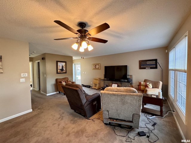 carpeted living room with ceiling fan and a textured ceiling